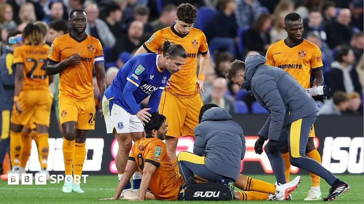 Players attending to an injured teammate on pitch