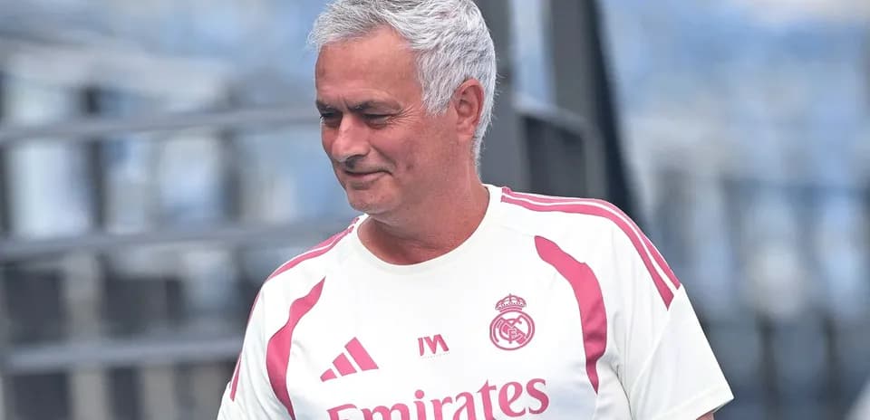 Coach wearing Real Madrid training kit on pitch