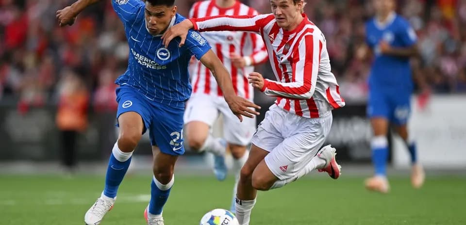 Player in blue and player in red competing for the ball