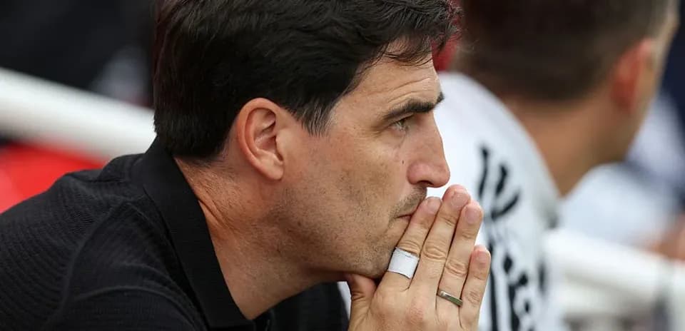 Coach observing match with hands clasped together