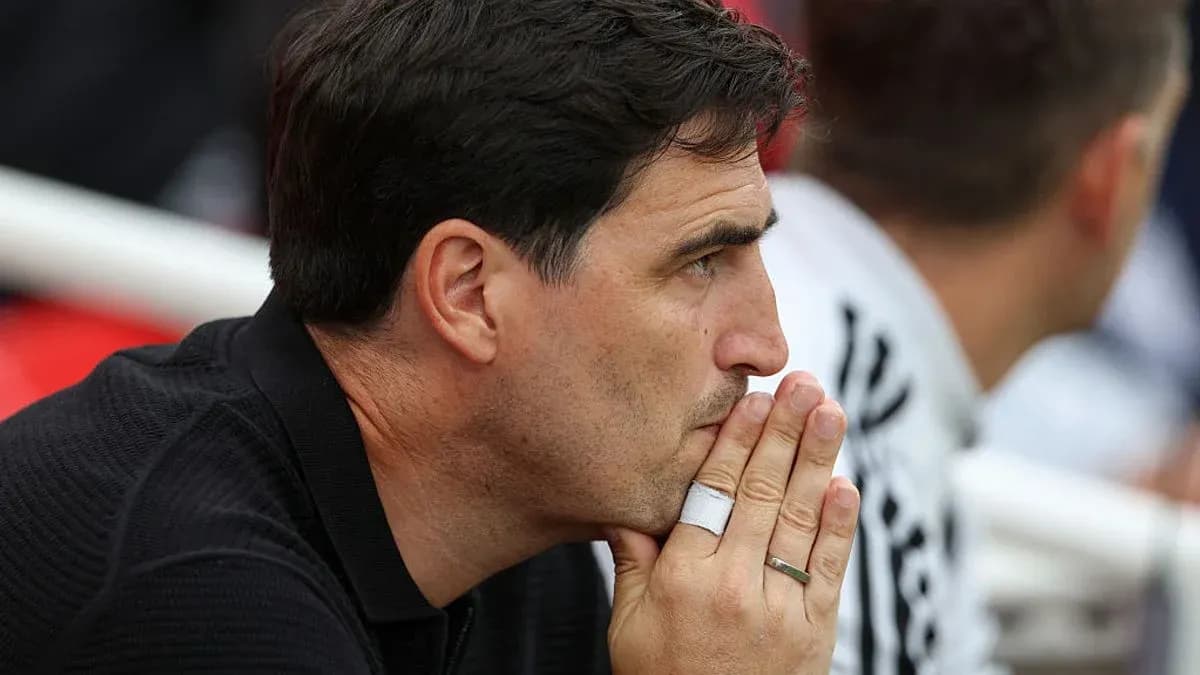 Coach observing match with hands clasped together