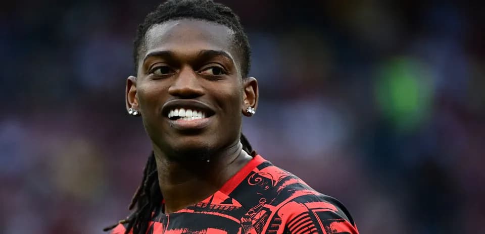 Player smiling in red patterned jersey on field