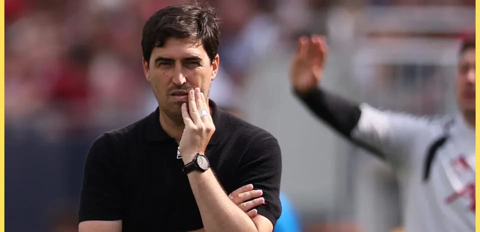 Coach observing the match with a thoughtful expression