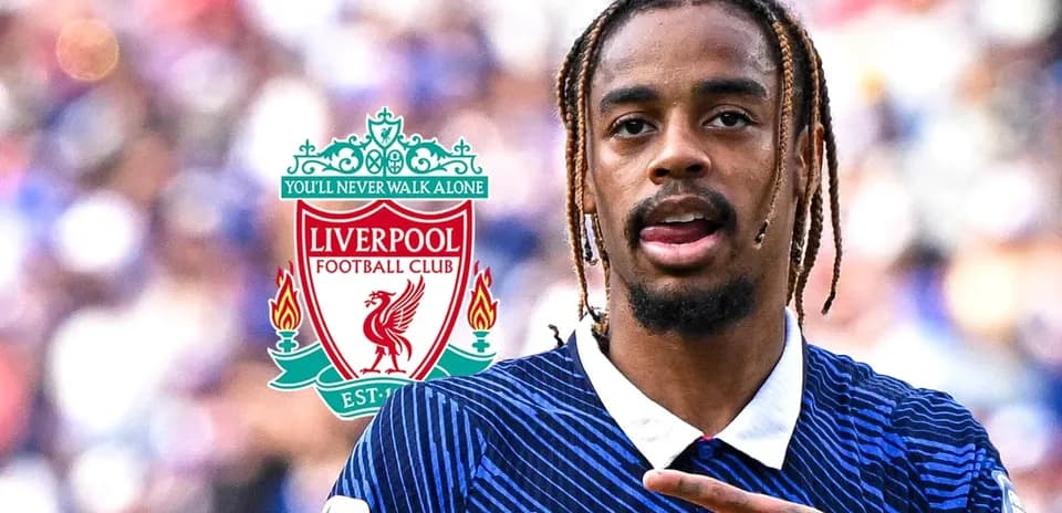 Player gesturing in front of Liverpool FC logo