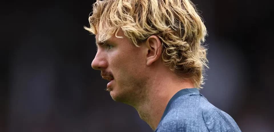 Player with blonde curly hair during match preparation