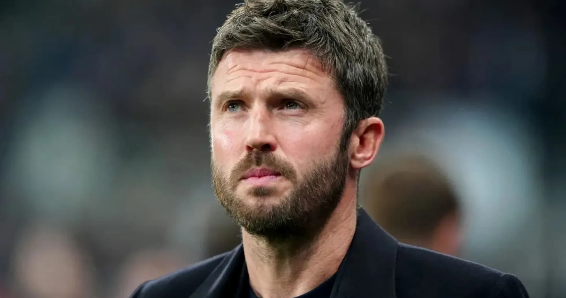 Man with short hair and beard looking thoughtfully