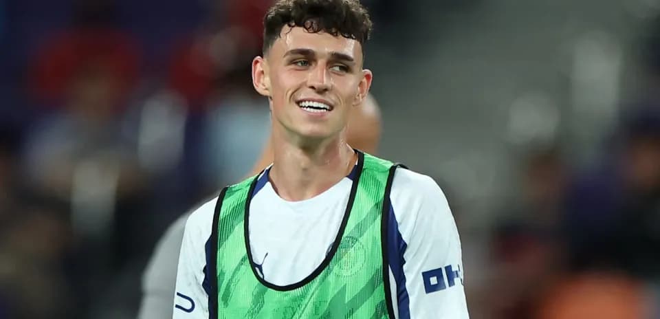 Player in training vest smiling on the pitch