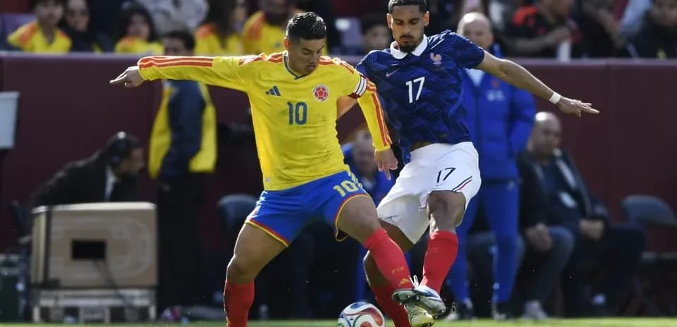 Colombian player challenging French opponent for the ball