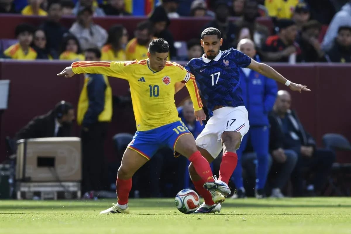 Colombian player challenging French opponent for the ball