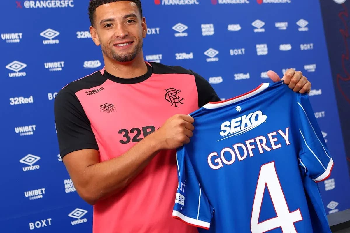 Player holding new jersey at press conference