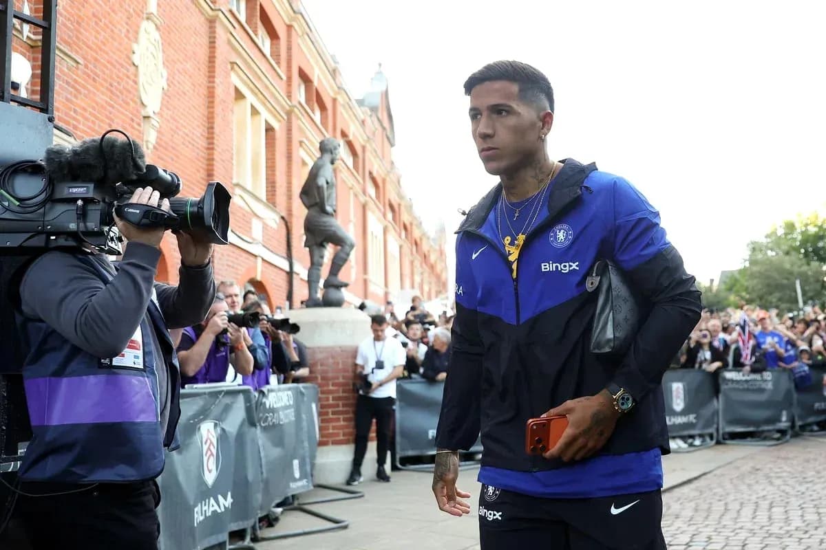 Player walking past photographers outside stadium