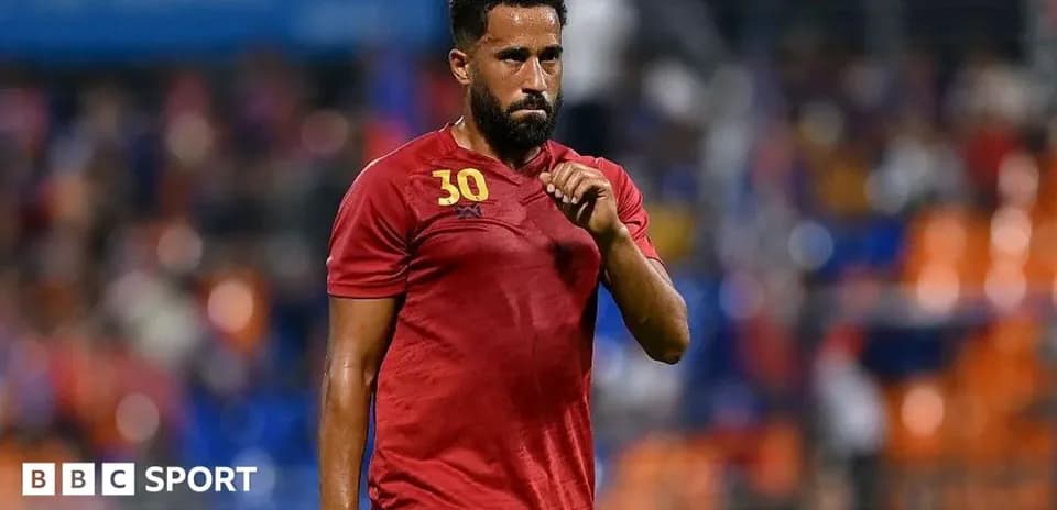 Player walking on the field in red jersey
