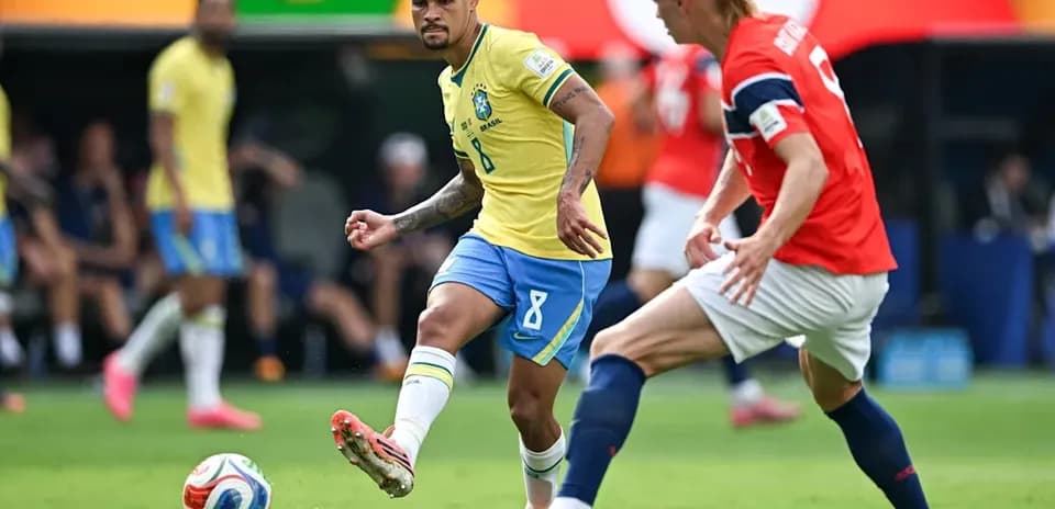 Brazilian player dribbling past Norwegian defender during match