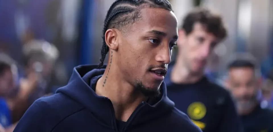 Player with braids walking in team hoodie