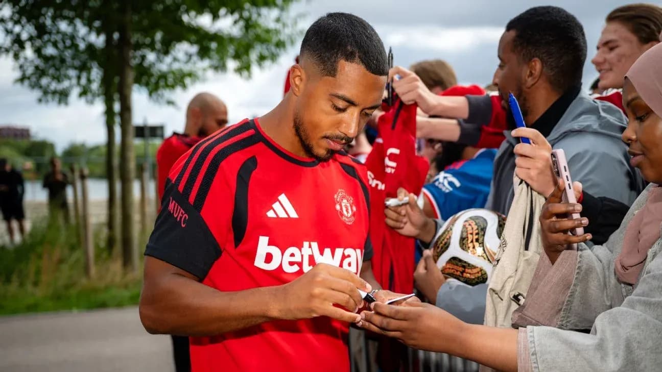 Player signing autographs for fans at event