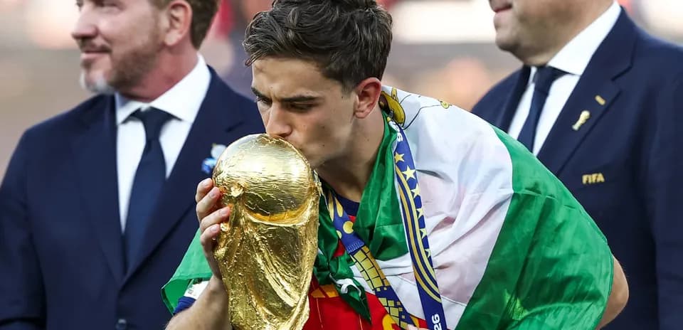 Player kissing World Cup trophy with national flag
