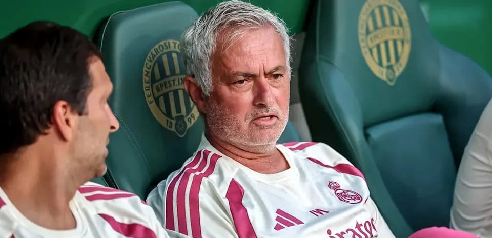 Two coaches sitting on the bench during match