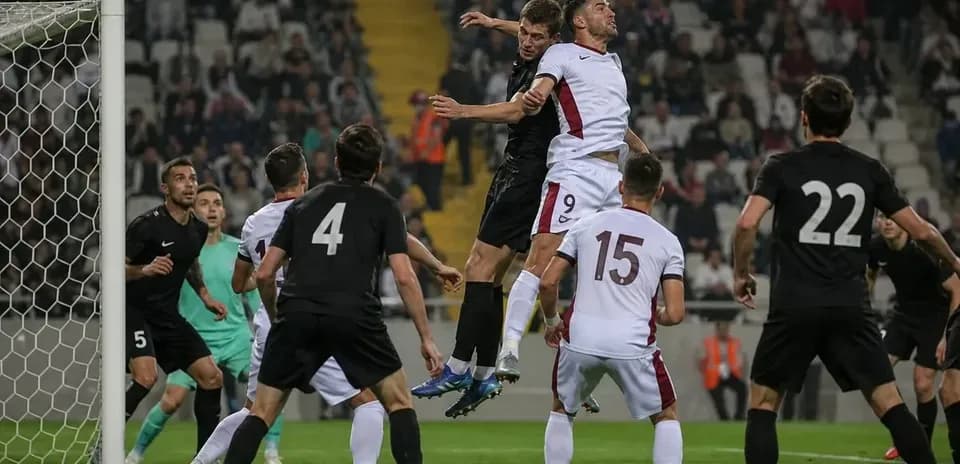 Players contesting a high ball in penalty area