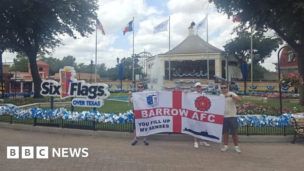 Two fans holding Barrow AFC flag at Six Flags