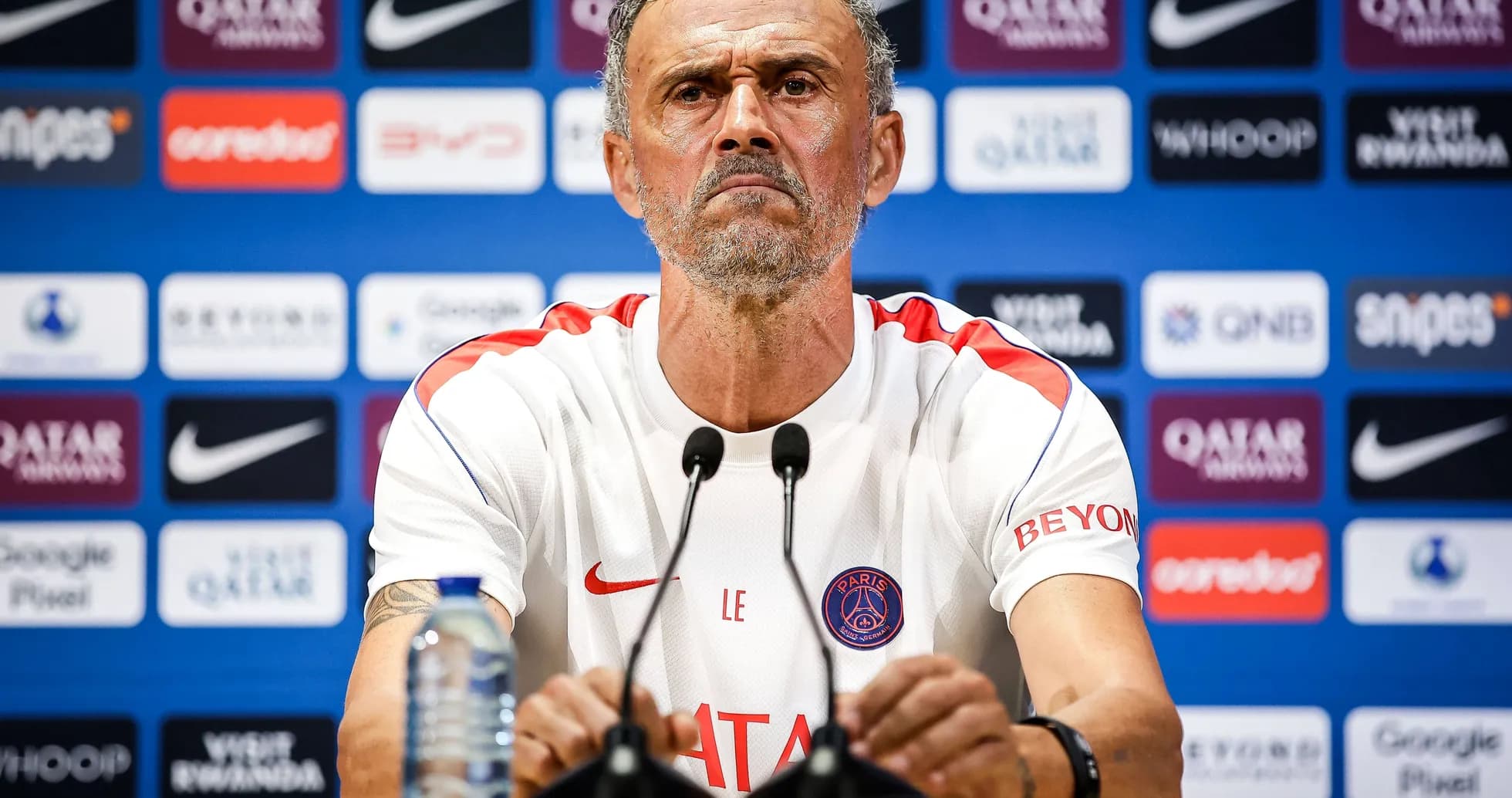 Manager at press conference with sponsor backdrop