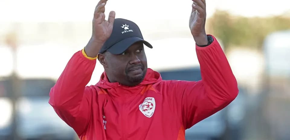 Coach gesturing during training session in red jacket