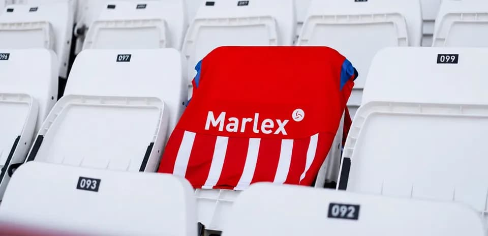 Red jersey with white stripes on empty stadium seat