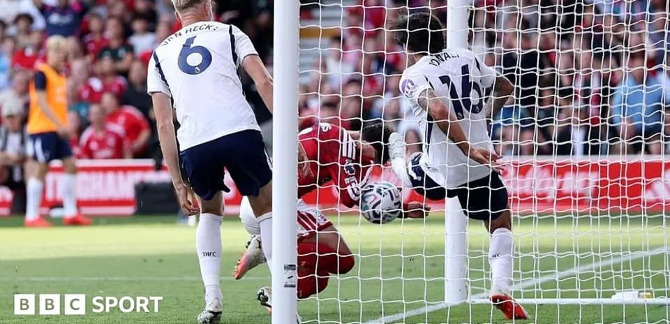 Goalkeeper attempting to save ball in goal area