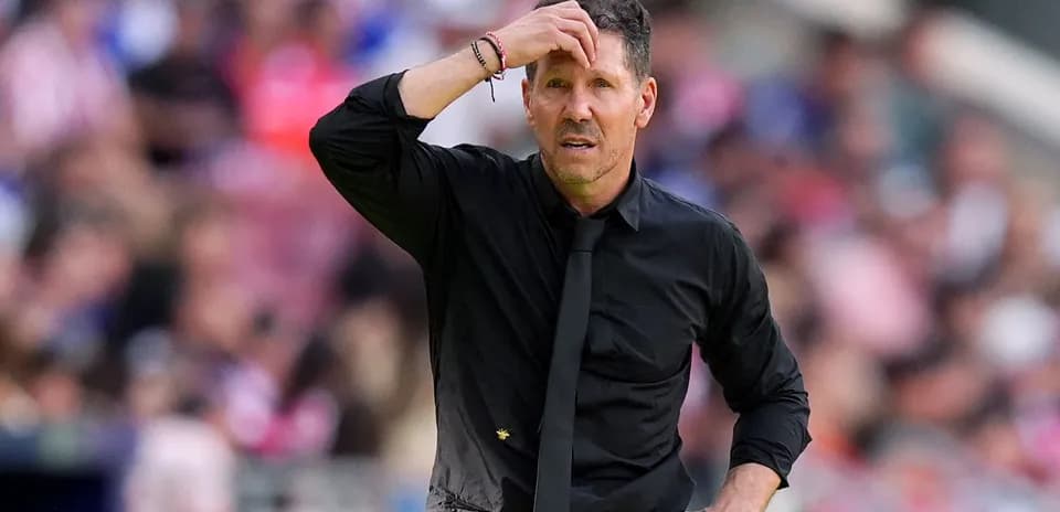 Coach with hand on forehead during match