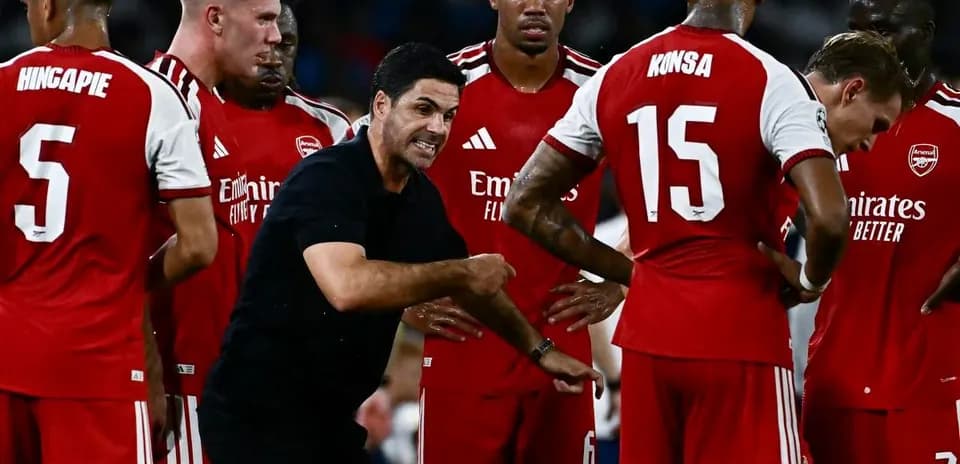 Arsenal manager instructing players during team huddle