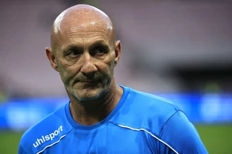 Coach in blue training kit on the pitch