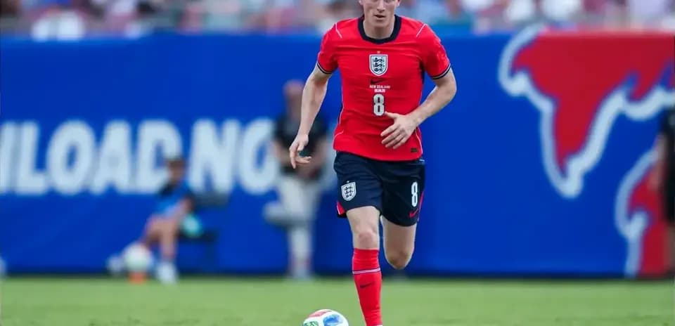 Player in red jersey running with soccer ball