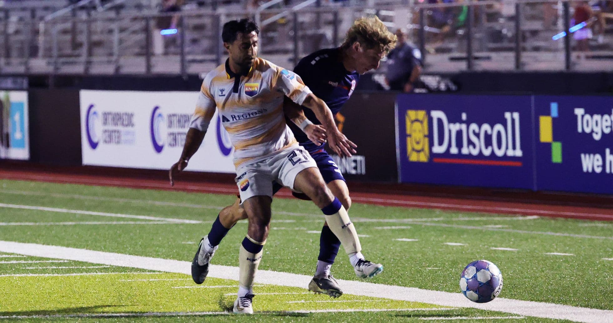 Players competing for the ball in football match