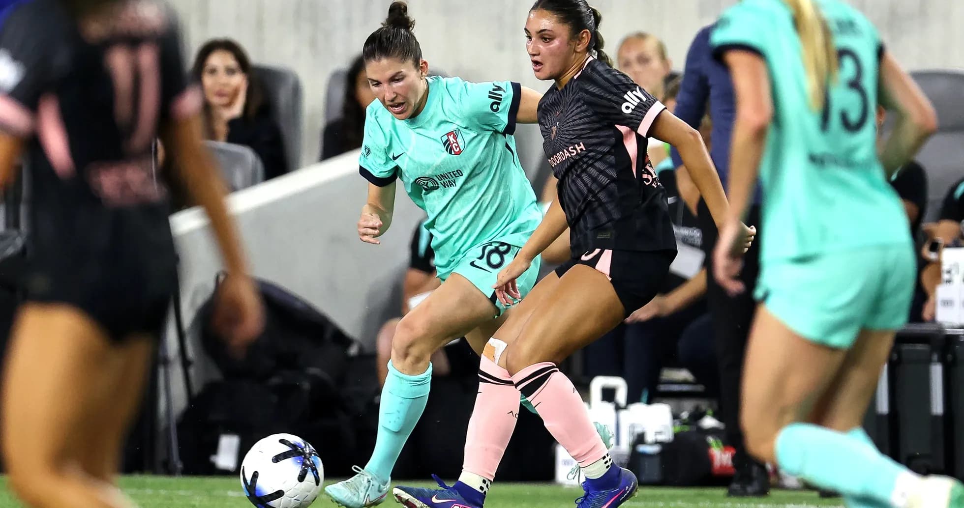 Two players competing for the ball in NWSL match