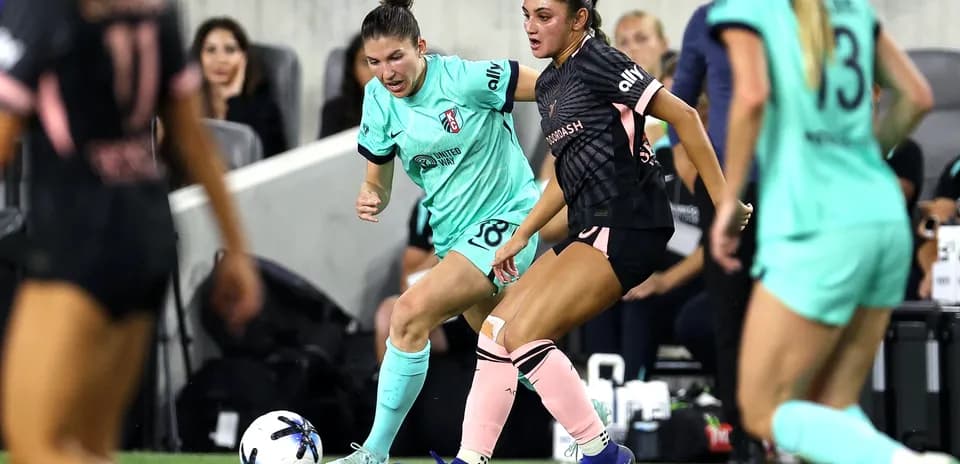 Two players competing for the ball in NWSL match