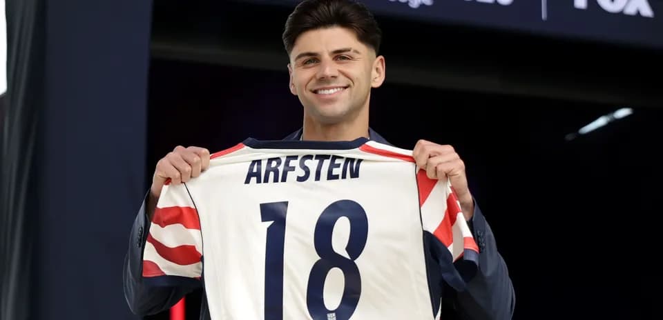 Player holding jersey with name 'ARFSTEN' and number 18