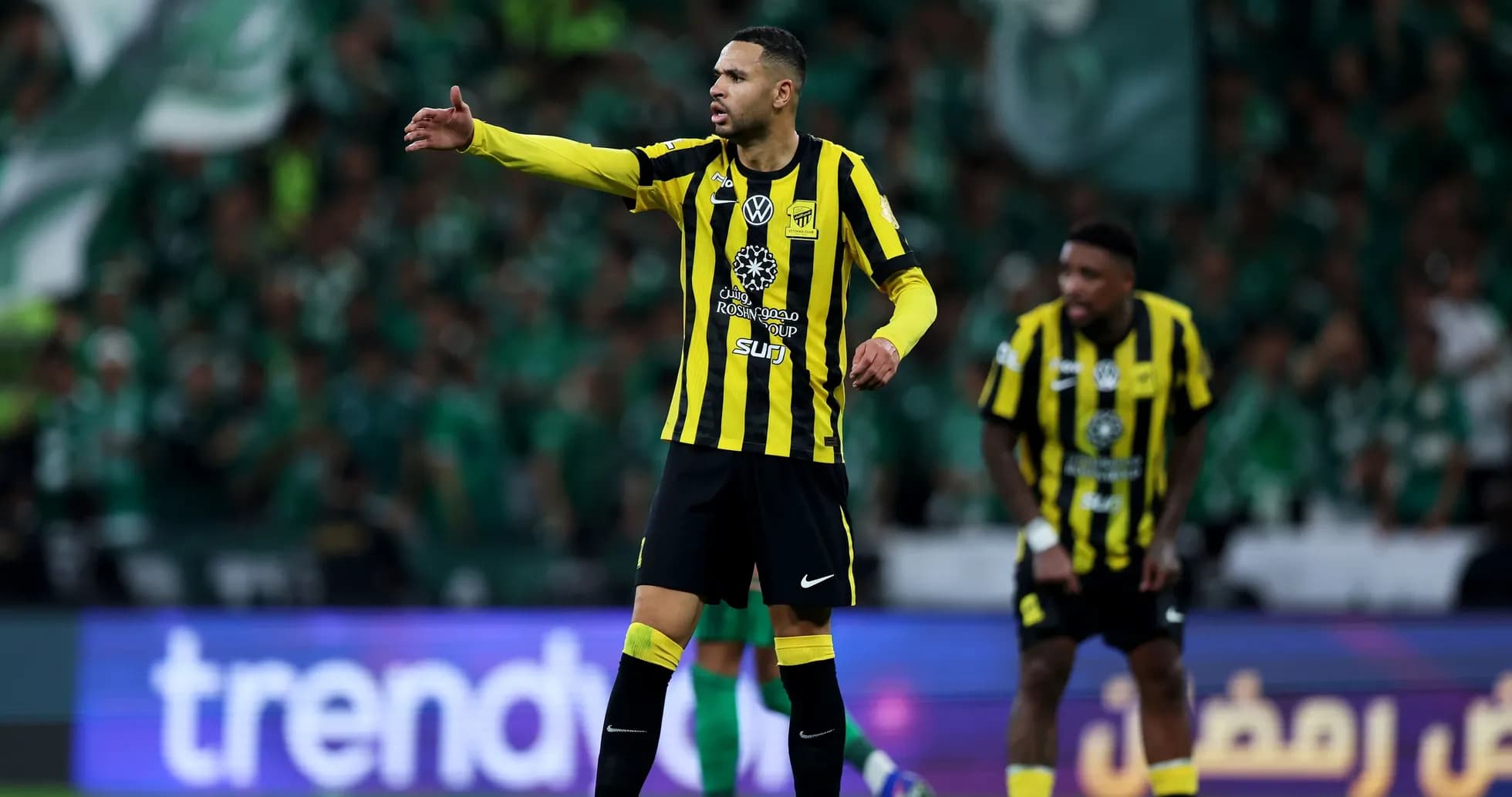 Player gesturing during a match with fans in background