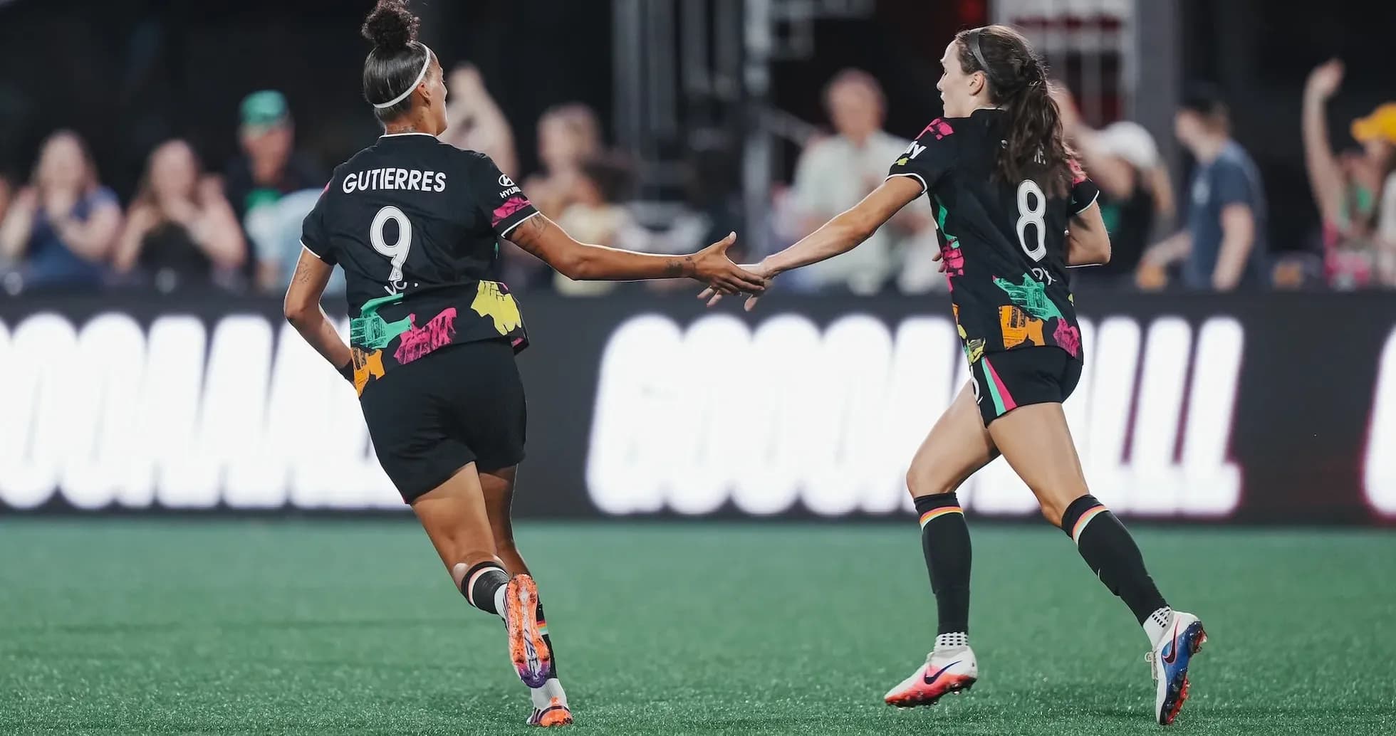 Players celebrating a goal during NWSL match