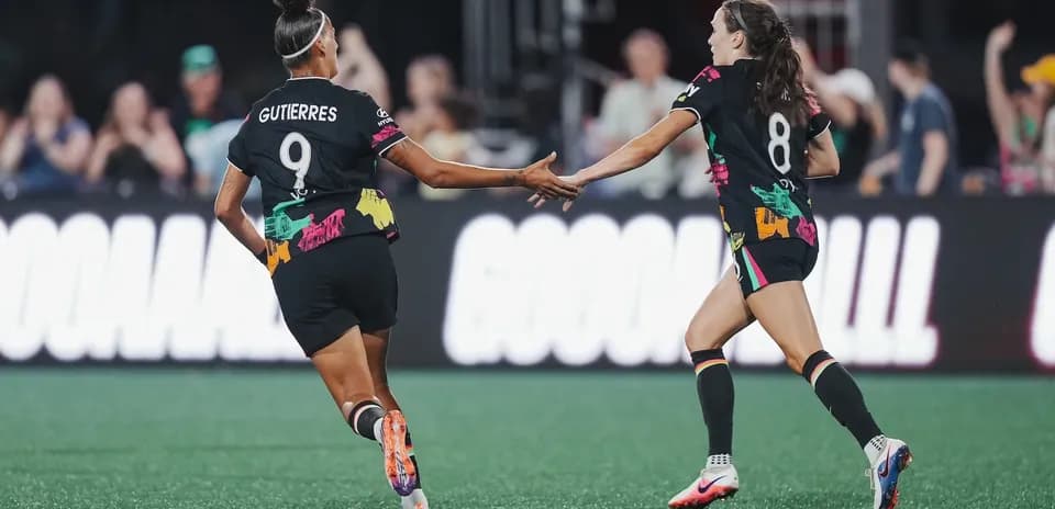Players celebrating a goal during NWSL match