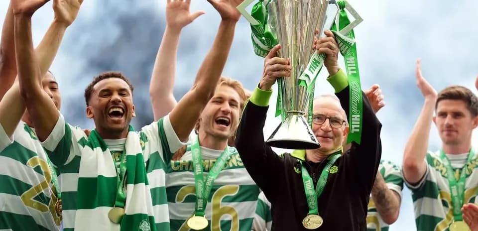 Celtic players celebrating with trophy on stage