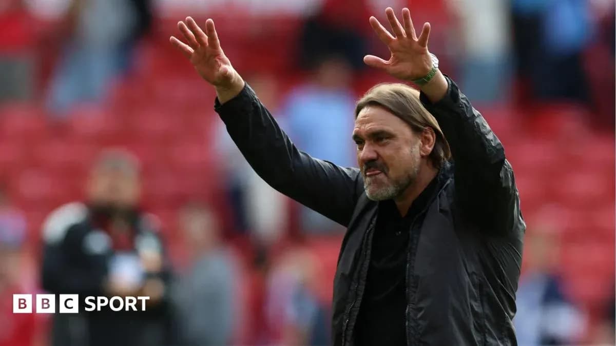 Manager gesturing to fans in stadium stands