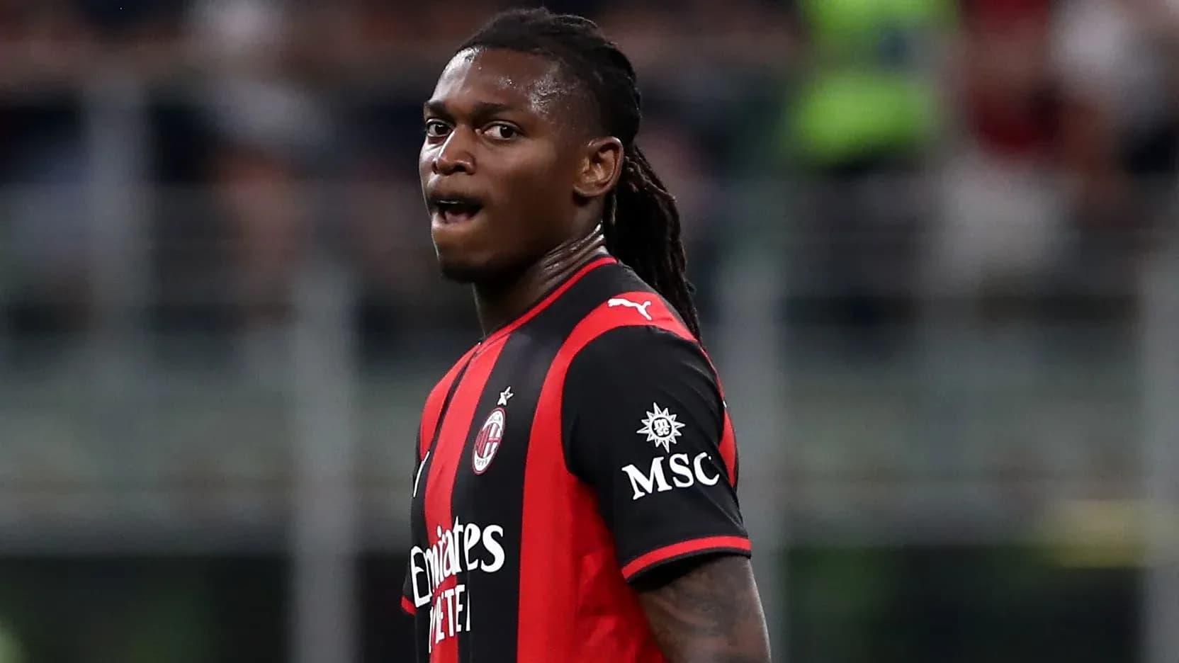 Player in AC Milan jersey during match action