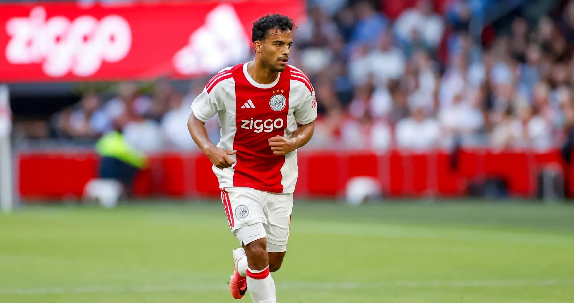 Player in Ajax kit running on the pitch