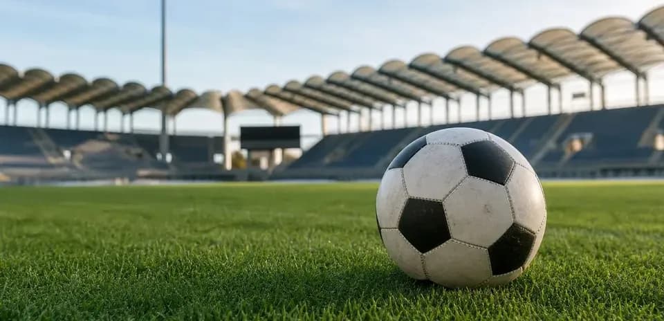 Soccer ball on grass at empty stadium