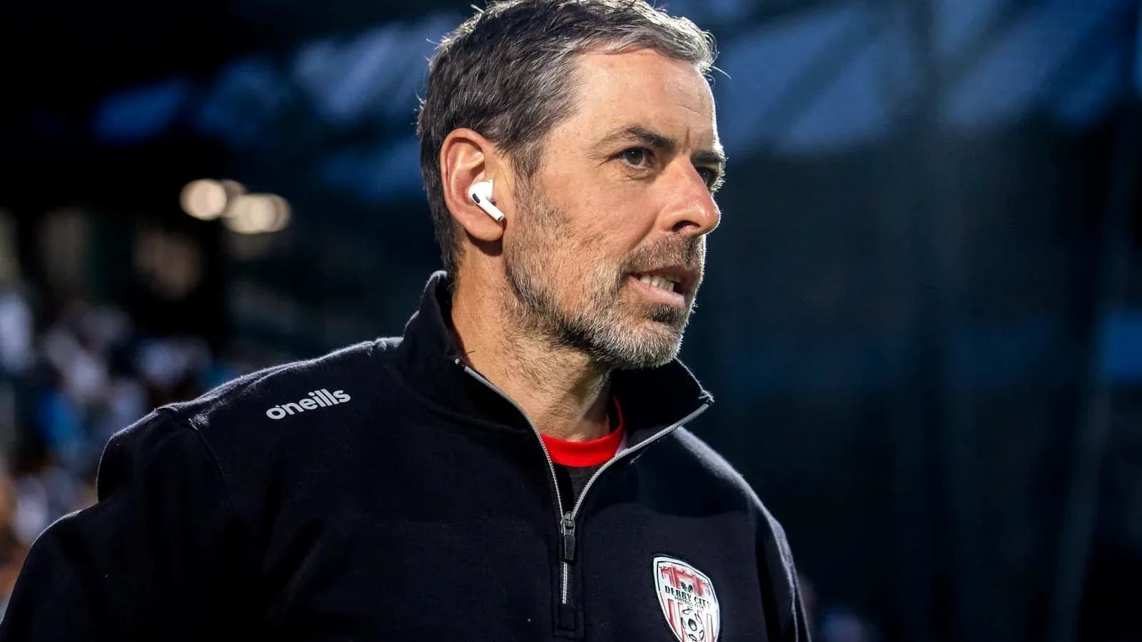 Coach wearing earphones during a match