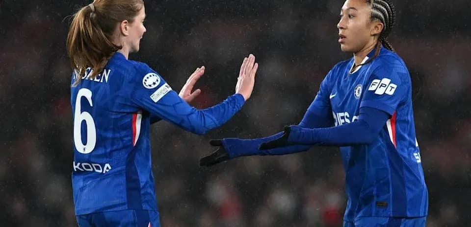 Two Chelsea players exchanging a high five on field