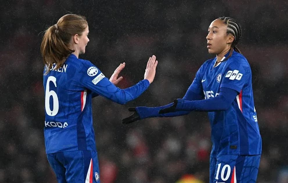 Two Chelsea players exchanging a high five on field
