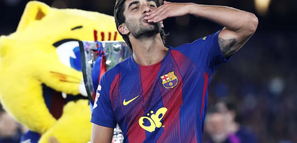 Player celebrating with trophy and mascot in background
