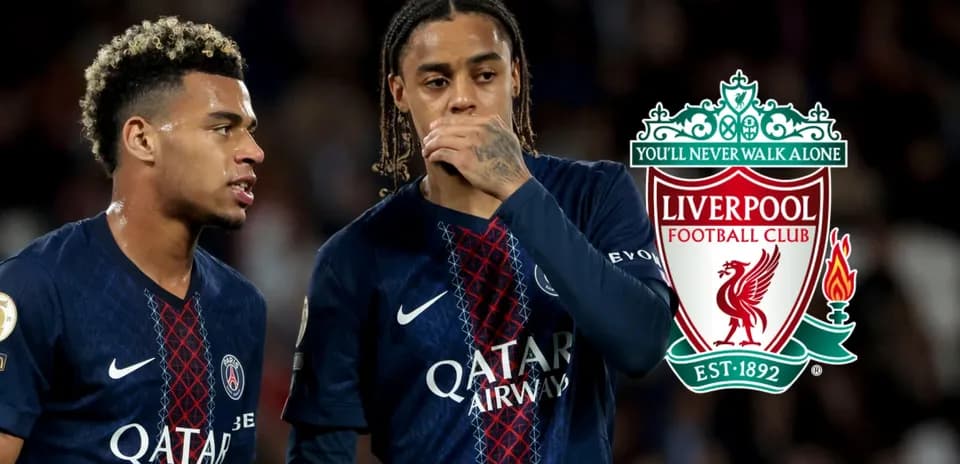 Two players discussing during a match, Liverpool logo