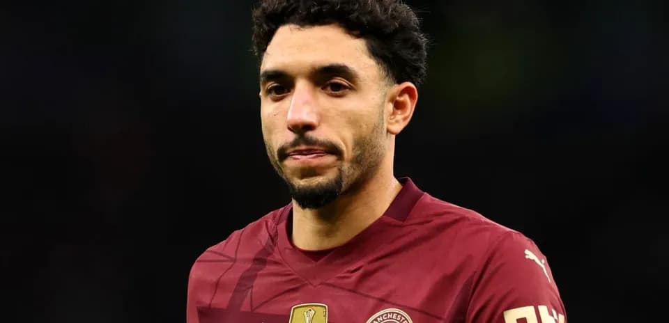 Player wearing maroon Manchester City jersey during match