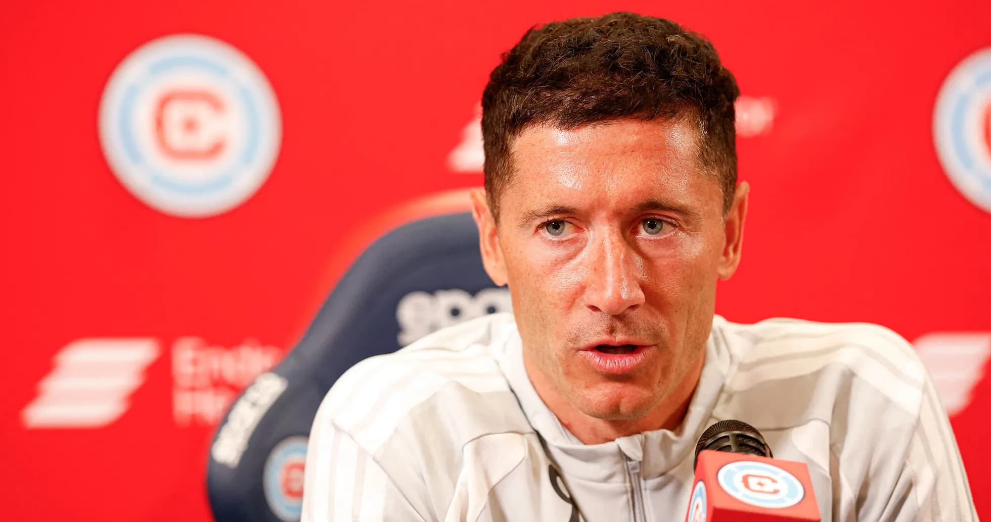 Player speaking at press conference with microphone